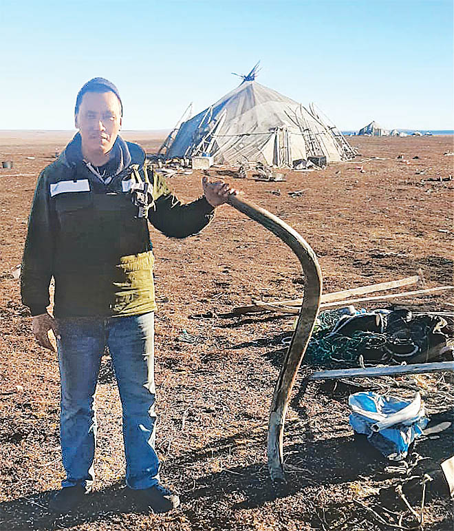 Алексей Тынескин сфотографировался с бивнем на память. Что делать с находкой дальше, оленеводы пока не решили.